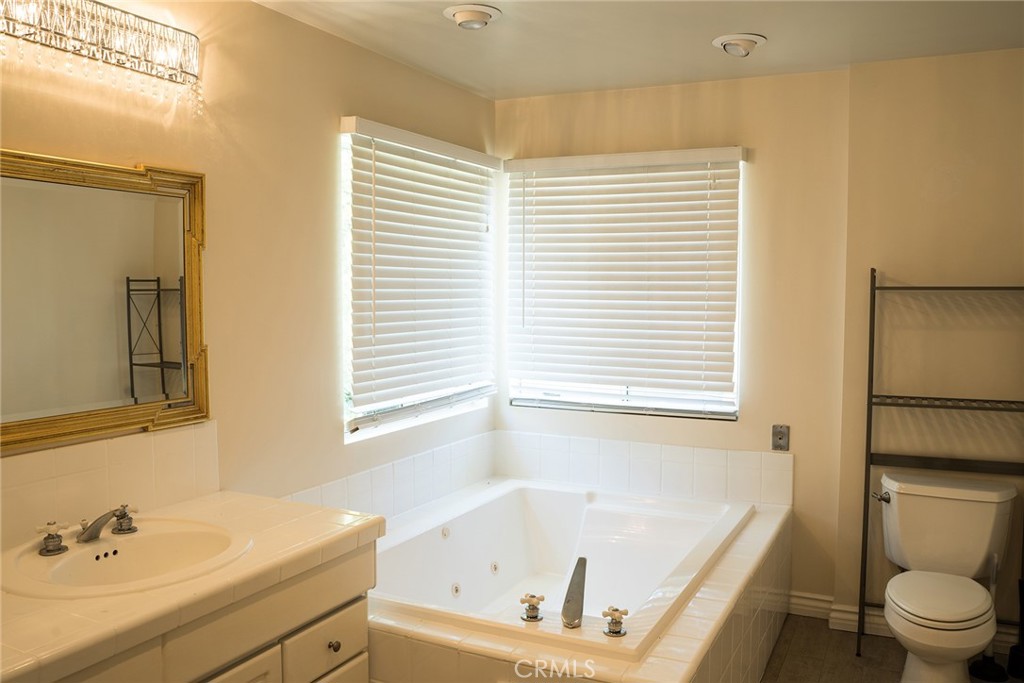 720 Heatherside Road Pasadena, CA 91105 - Photo 8 of 23 a white bath tub sitting next to a white sink and a toilet