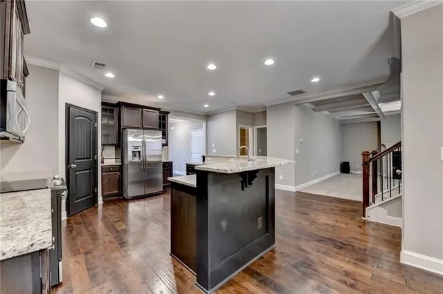 a modern kitchen with stainless steel appliances granite countertop a sink and a refrigerator