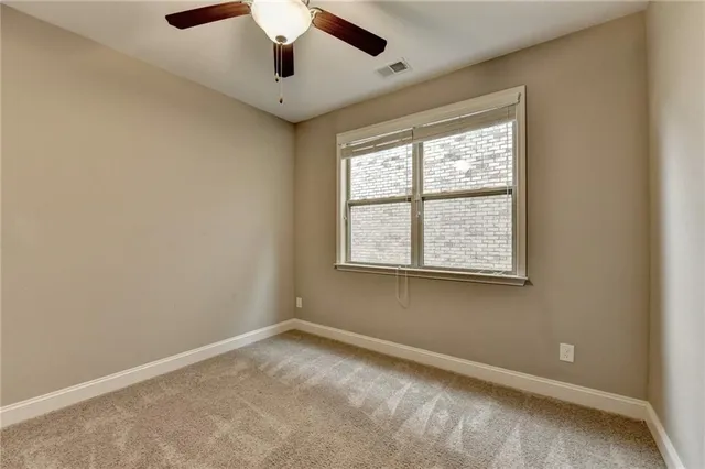 an empty room with closet and fan