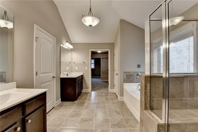 an empty room with ceiling fan and windows