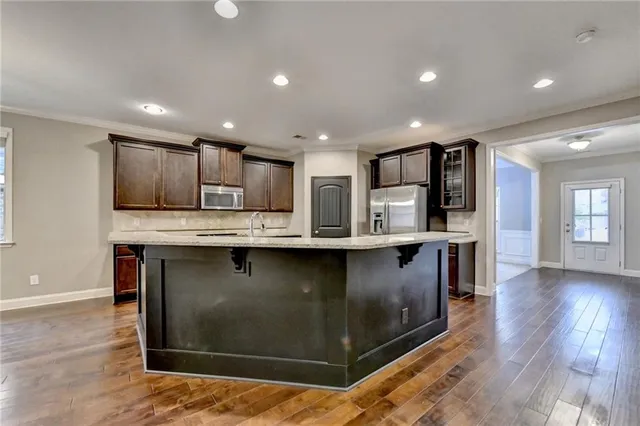 a kitchen with stainless steel appliances granite countertop a stove a sink and a refrigerator