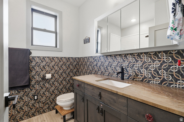 175 North 100 West Providence, UT 84332 - Photo 20 of 45 Full bathroom featuring vanity, light wood-style flooring, a wainscoted wall, and tile walls