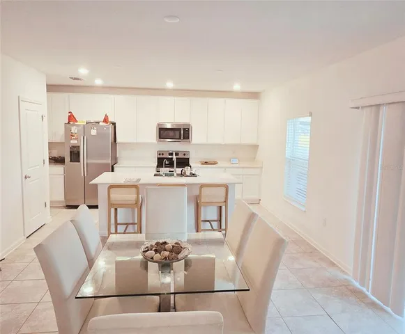 a living room with furniture and white appliances