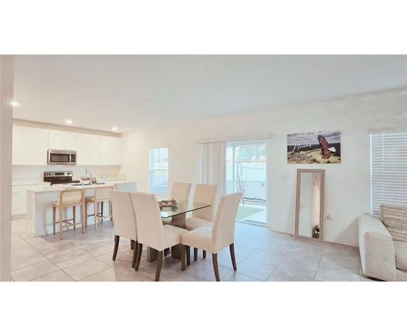 a dining room with furniture and kitchen view