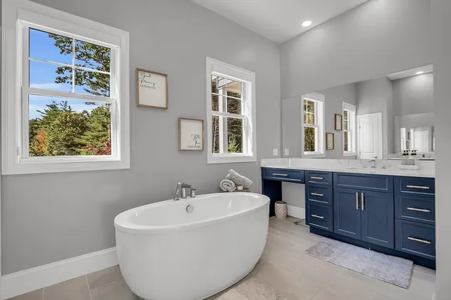 a bathroom with a tub sink and mirror