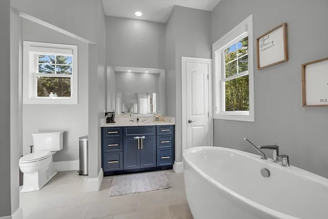 a bathroom with a tub sink toilet and mirror