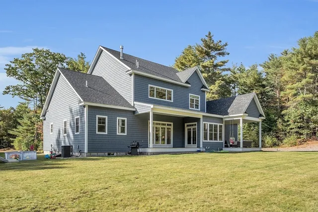 a view of a house with a big yard and large trees