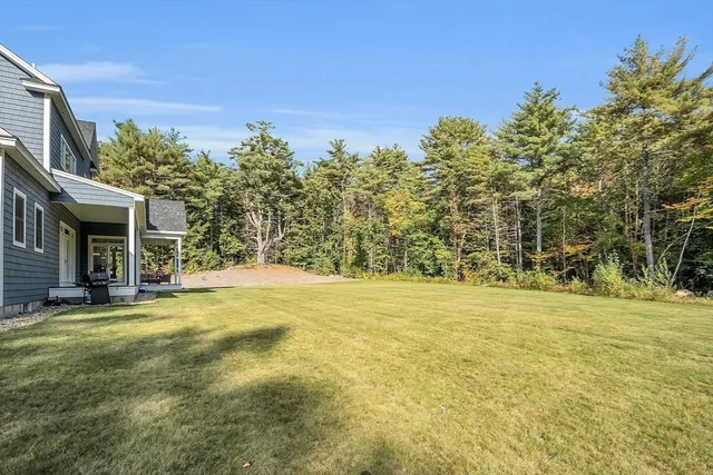 a view of a brick house with a big yard and large trees