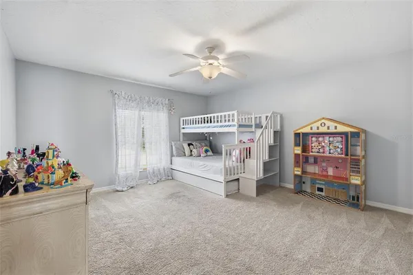a bedroom with furniture a baby crib and a window