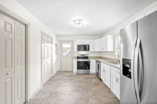a kitchen with stainless steel appliances granite countertop a refrigerator and a stove top oven