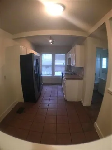 a kitchen with stainless steel appliances a refrigerator a sink a stove and white cabinets