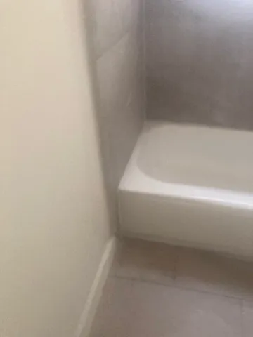 a white bath tub sitting next to a white toilet and a sink