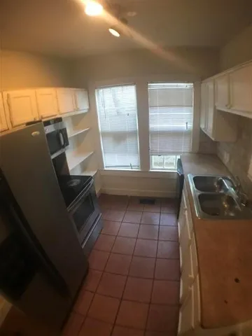 a kitchen with a sink a stove and cabinets