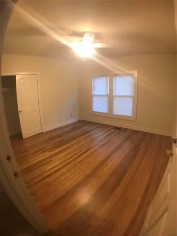 a view of a room with wooden floor and windows