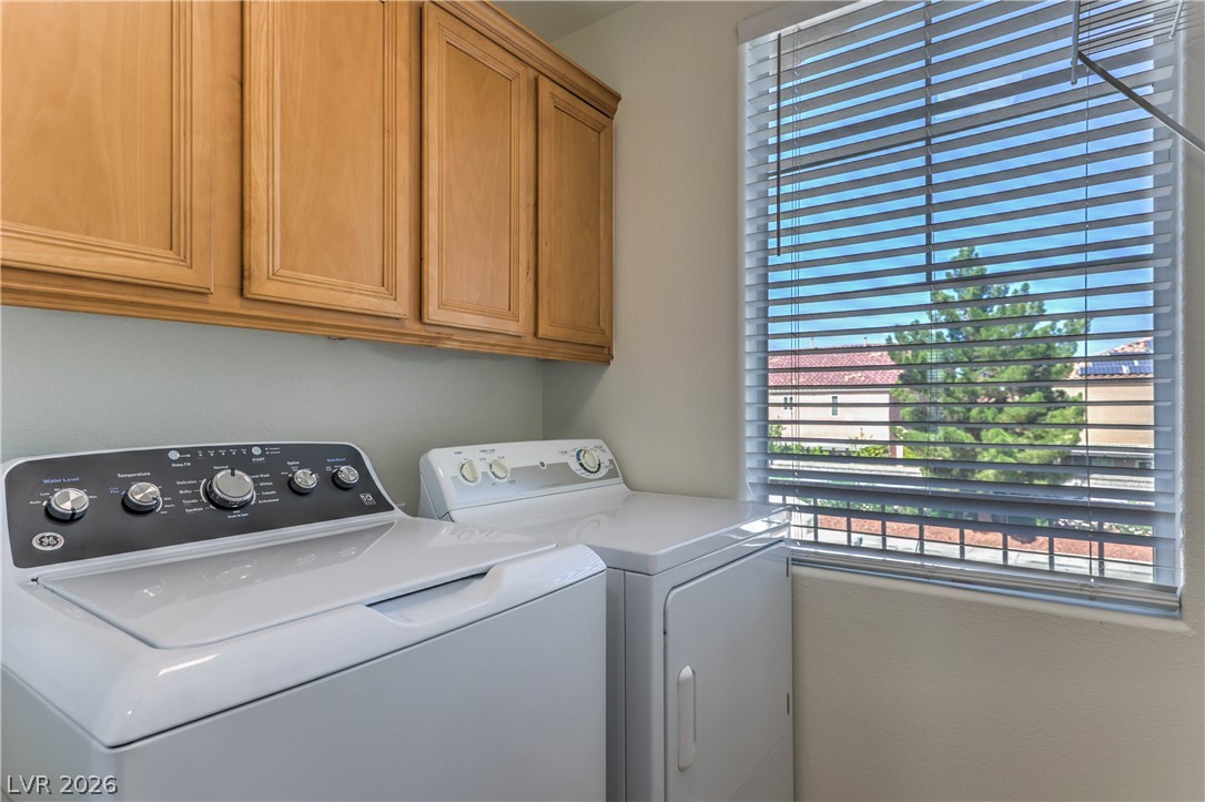 10939 Paradise Road Henderson, NV 89052 - Photo 32 of 36 Functional laundry space with overhead cabinetry and sunlit window.