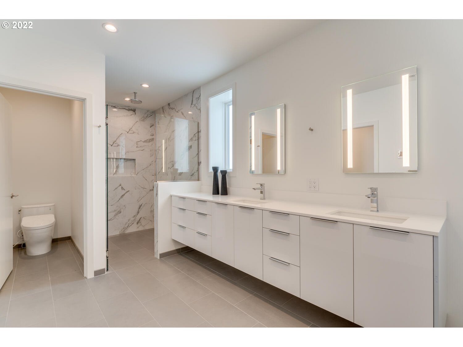 10424 Northwest Laidlaw Road Portland, OR 97229 - Photo 25 of 32 a spacious bathroom with a double vanity sink a mirror and a toilet