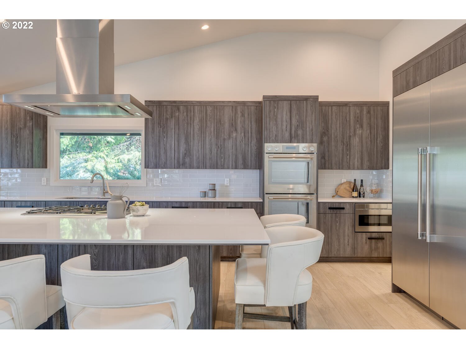 10424 Northwest Laidlaw Road Portland, OR 97229 - Photo 4 of 32 a kitchen with kitchen island a counter space and a refrigerator