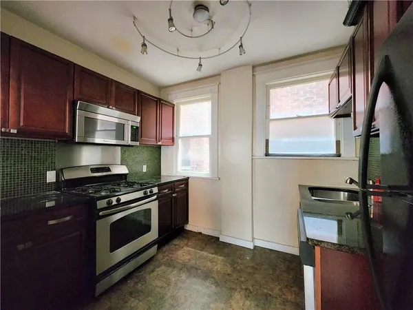 a kitchen with stainless steel appliances a stove a sink and a microwave