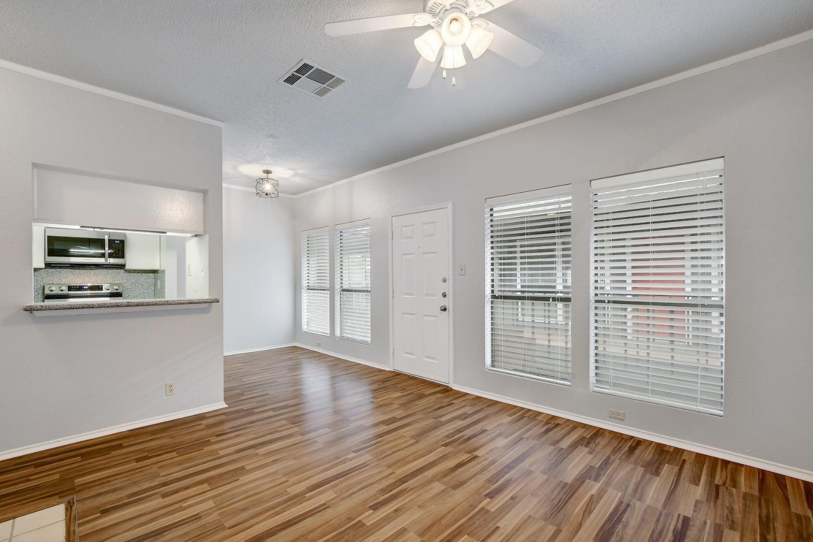 2804 Rio Grande Street, Unit 310 Austin, TX 78705 - Photo 7 of 22 Hardwood-style flooring and bright windows create an inviting atmosphere in this open living area.