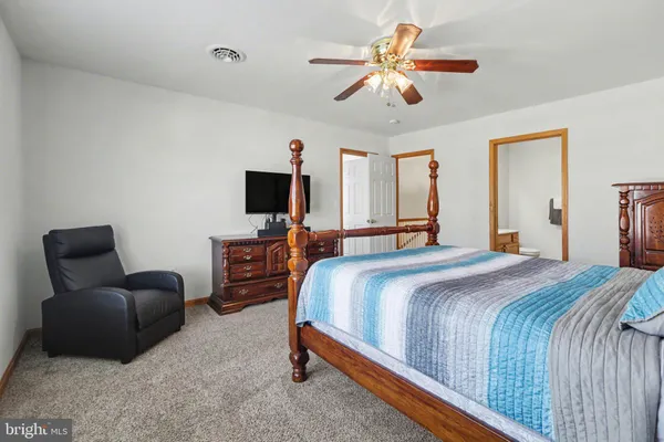 a bedroom with a bed couch and a window