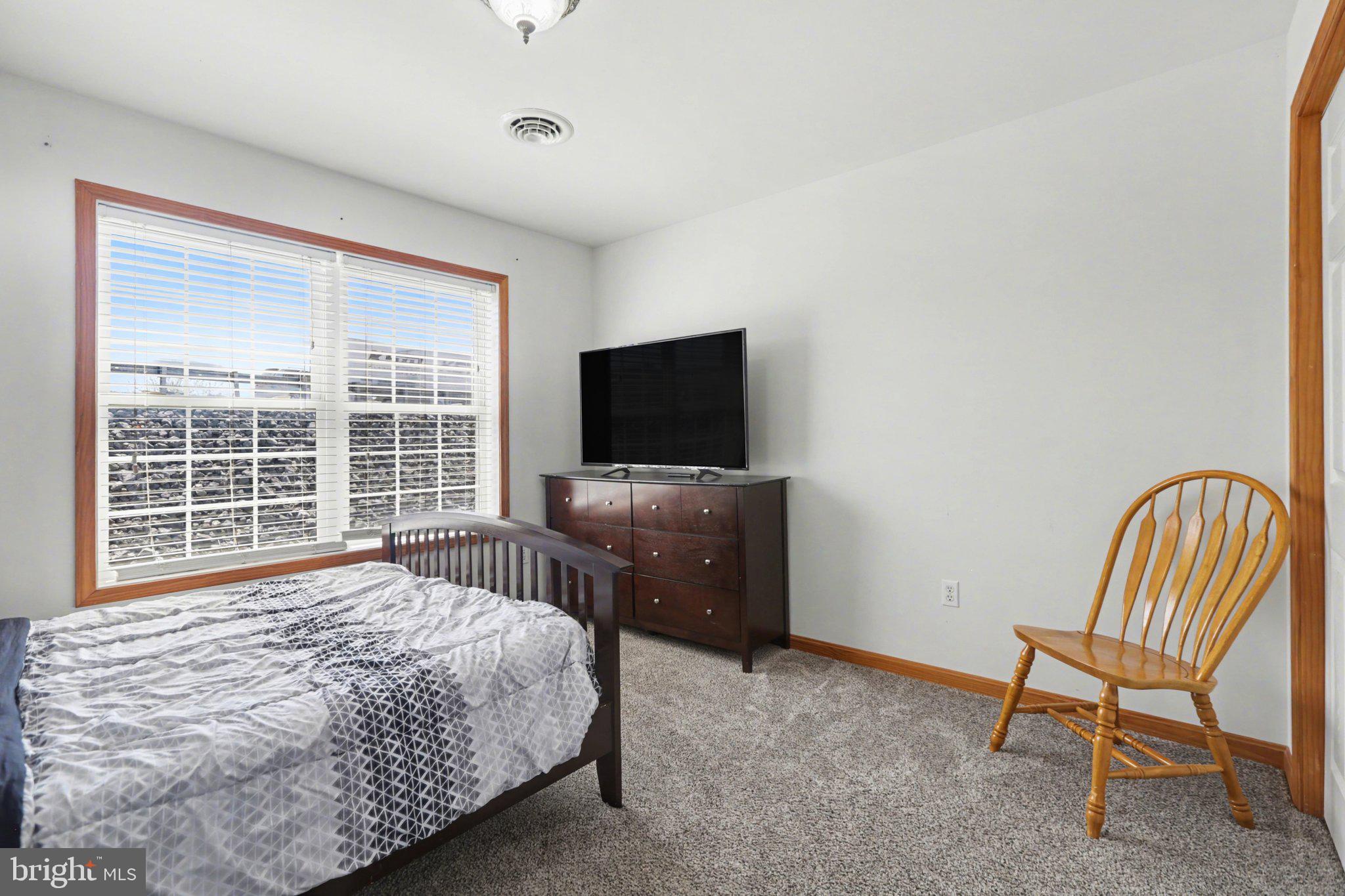 134 Sable Drive Carlisle, PA 17013 - Photo 18 of 37 a bedroom with a bed chair and flat screen tv