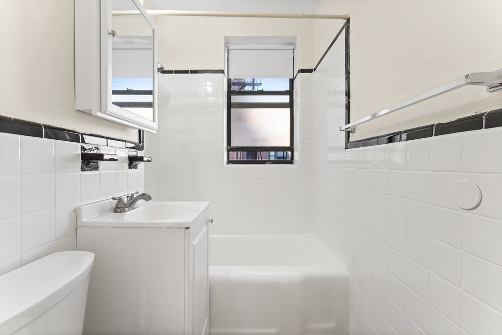 11 Victory Road, Unit 32 Boston, MA 02122 - Photo 6 of 16 a bathroom with a sink a toilet and shower
