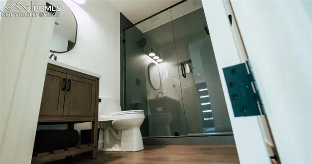 an entryway with wooden floor and a mirror