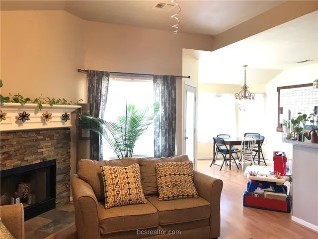 a living room with furniture fireplace and a large window