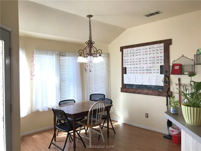 a view of a dining room with furniture and chandelier