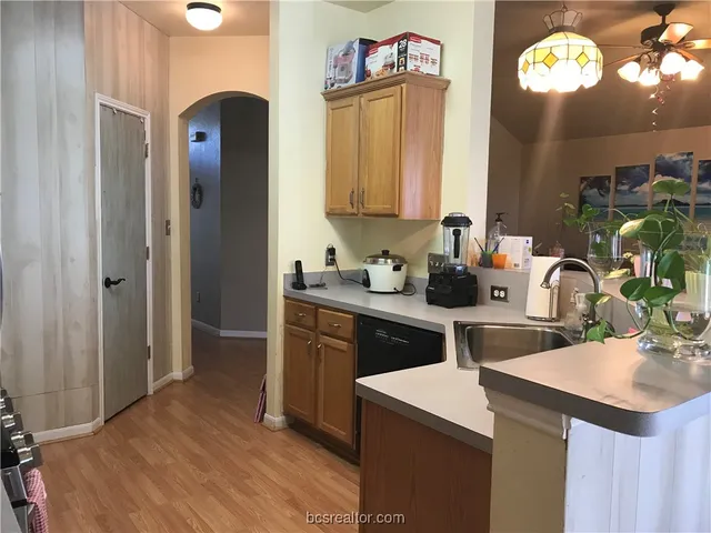 a kitchen with a sink cabinets and wooden floor