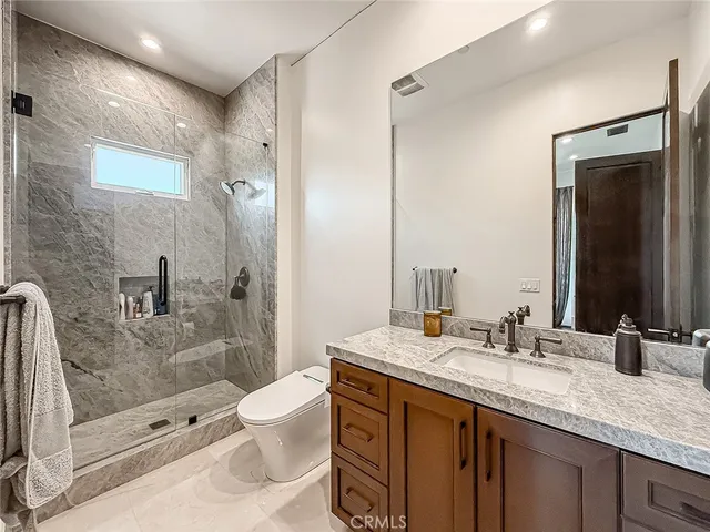 a bathroom with a granite countertop sink toilet and shower