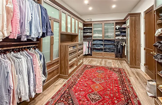 a view of walk in closet with clothes and shoes