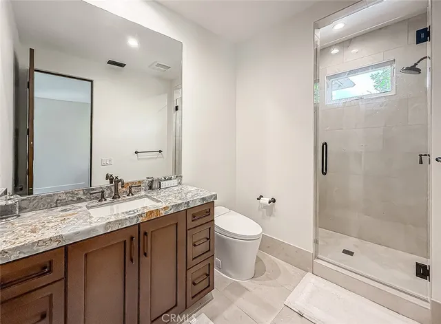 a bathroom with a granite countertop sink toilet and shower