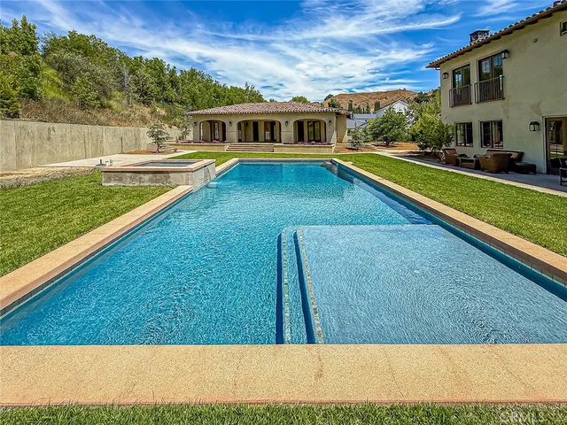 a view of an house with swimming pool and a yard