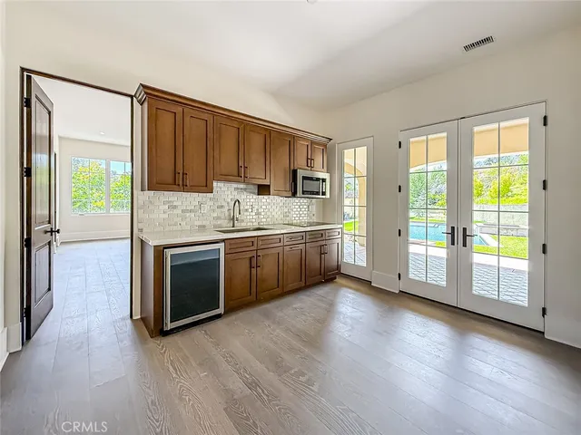 a kitchen with stainless steel appliances granite countertop a sink a microwave cabinets and a wooden floor
