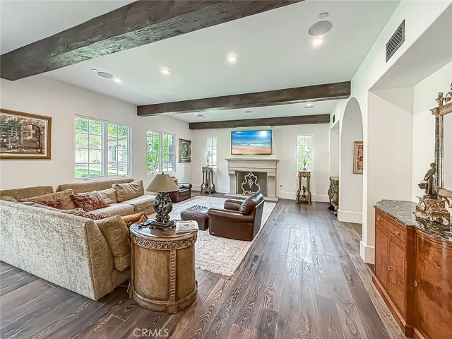 a living room with furniture a large window and wooden floor