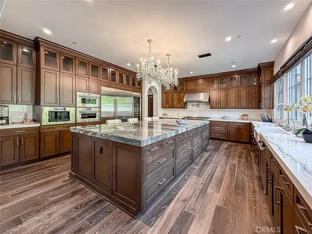 a kitchen with kitchen island granite countertop a sink stove and cabinets