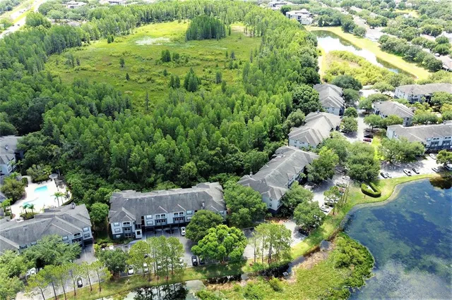 an aerial view of residential house with outdoor space and trees all around