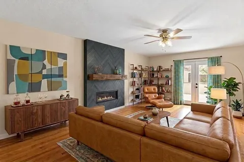 a living room with furniture fireplace and a window