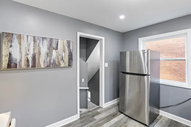 a view of kitchen with refrigerator and wooden floor