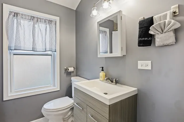a bathroom with a toilet a sink and a mirror