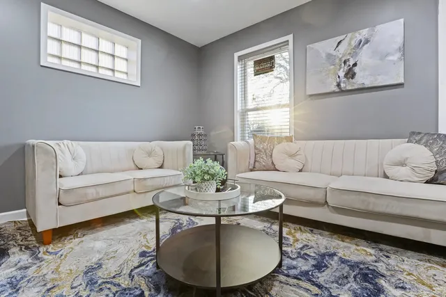 a living room with furniture a rug and a window