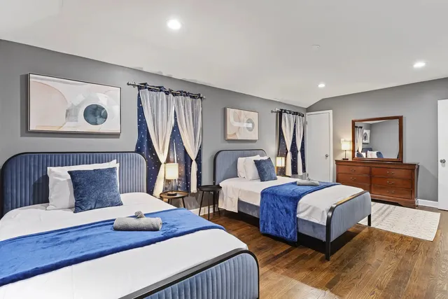 a bedroom with two beds and a large mirror