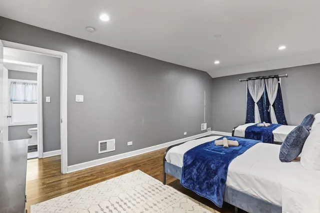 a bedroom with two beds and a rug