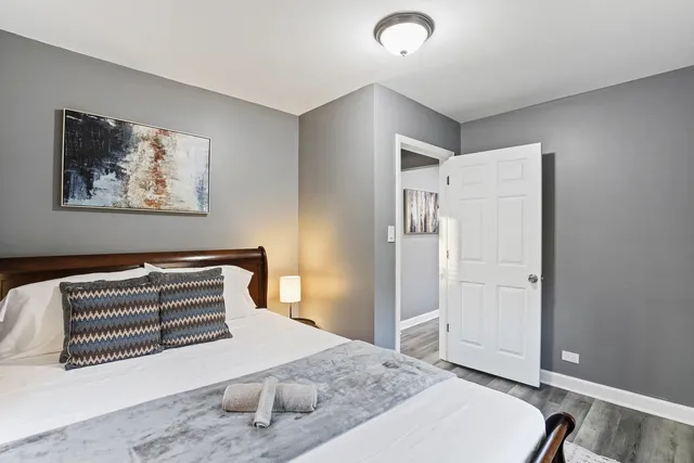 a bedroom with a bed and a painting on the wall