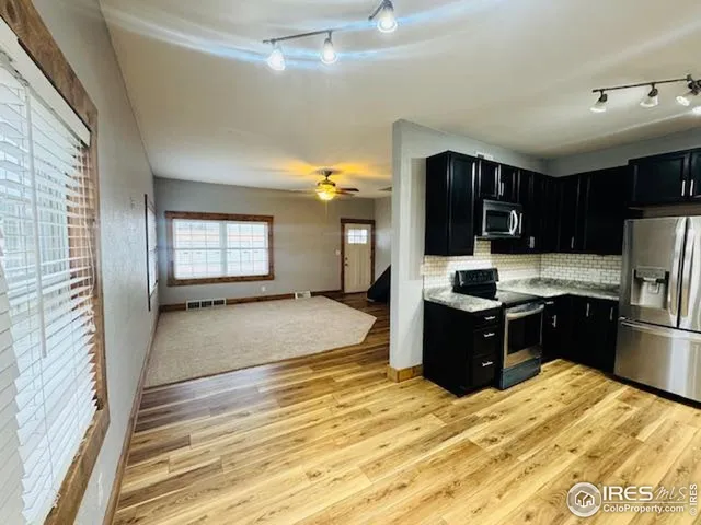 a kitchen with a refrigerator sink and cabinets