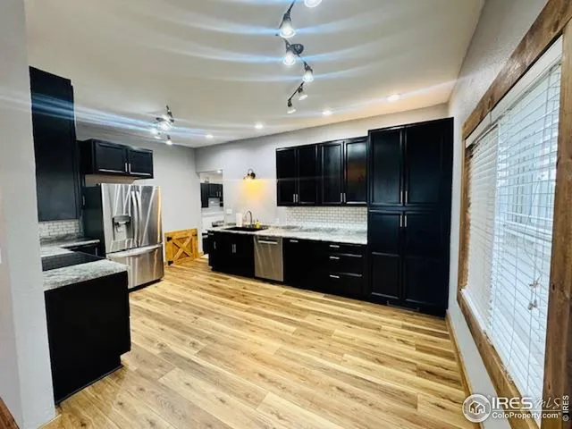 a large white kitchen with a sink stainless steel appliances and cabinets