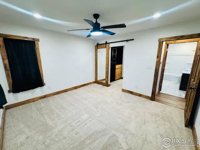 an empty room with closet and a ceiling fan