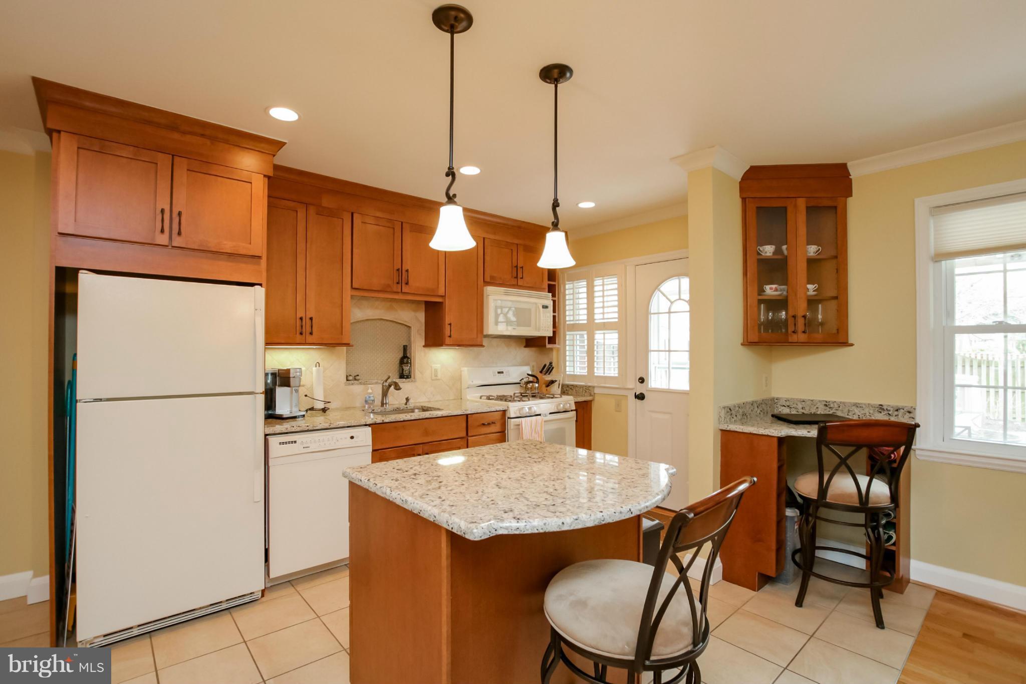 181 Dumbarton Road Baltimore, MD 21212 - Photo 2 of 30 a kitchen with stainless steel appliances granite countertop a sink a refrigerator a stove a dining table and chairs with wooden floor
