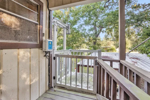 a view of a balcony with chairs and wooden floor